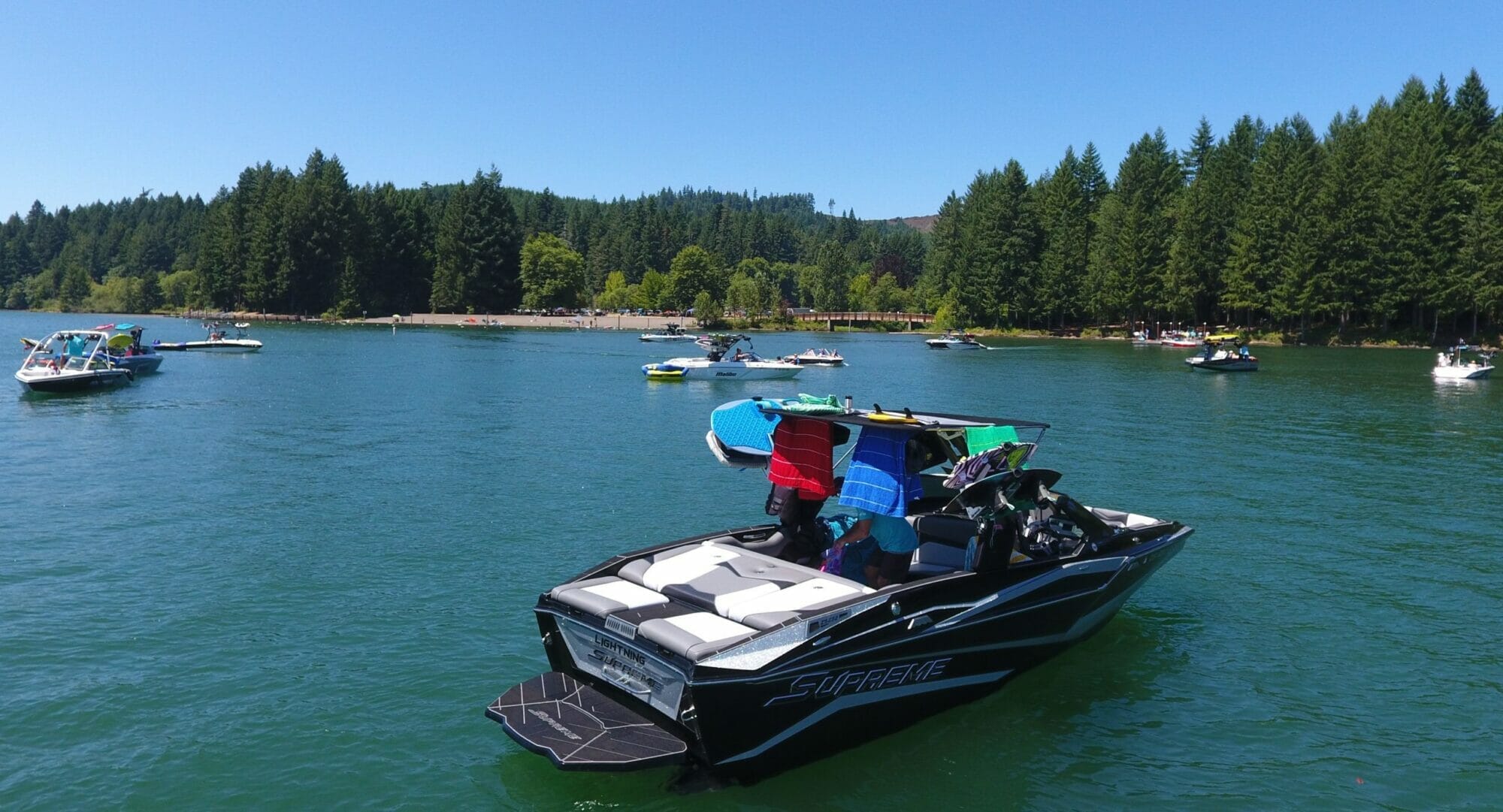 A group of people on a Supreme boat in the middle of a lake.