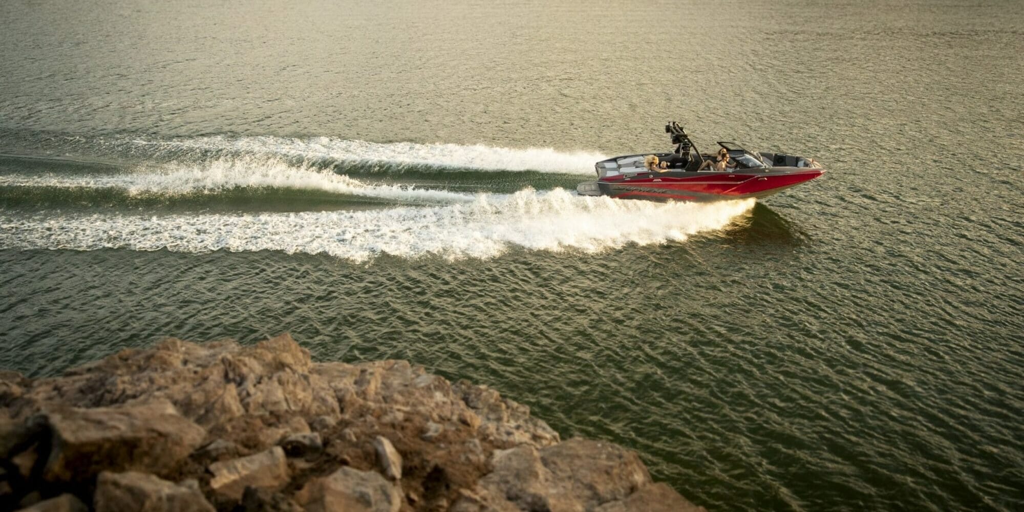 A Supreme speed boat is driving on a lake.