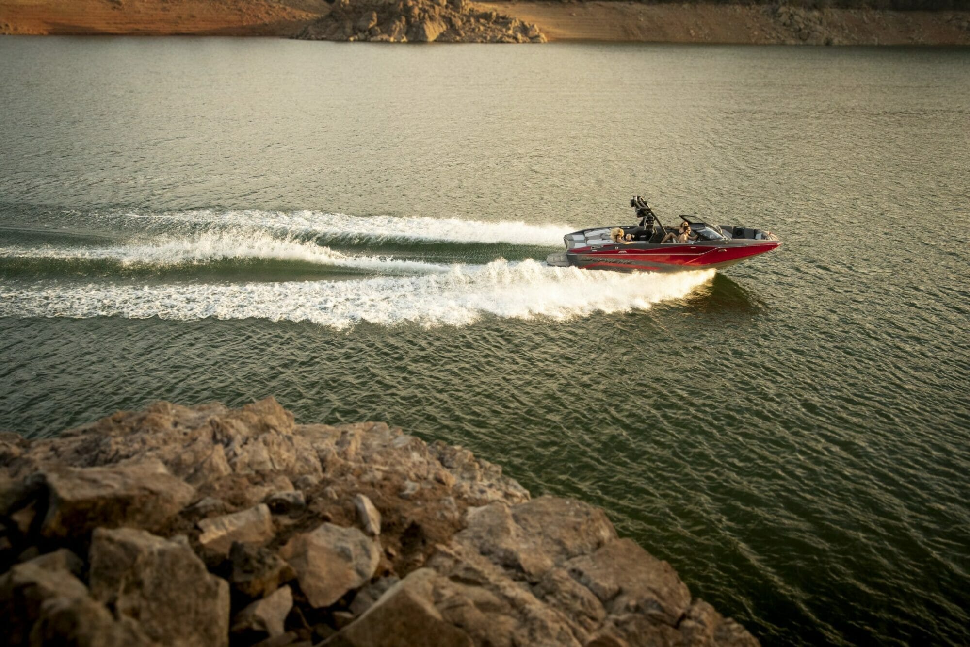 A Supreme speed boat is driving on a lake.