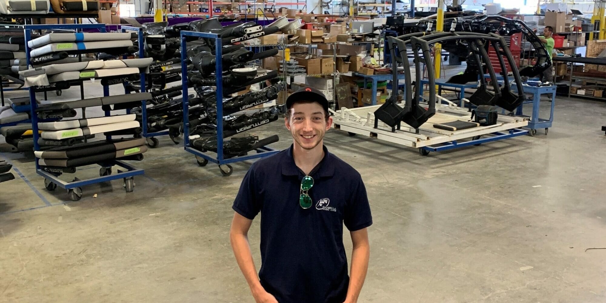 A young man in a warehouse full of Supreme Boats equipment.