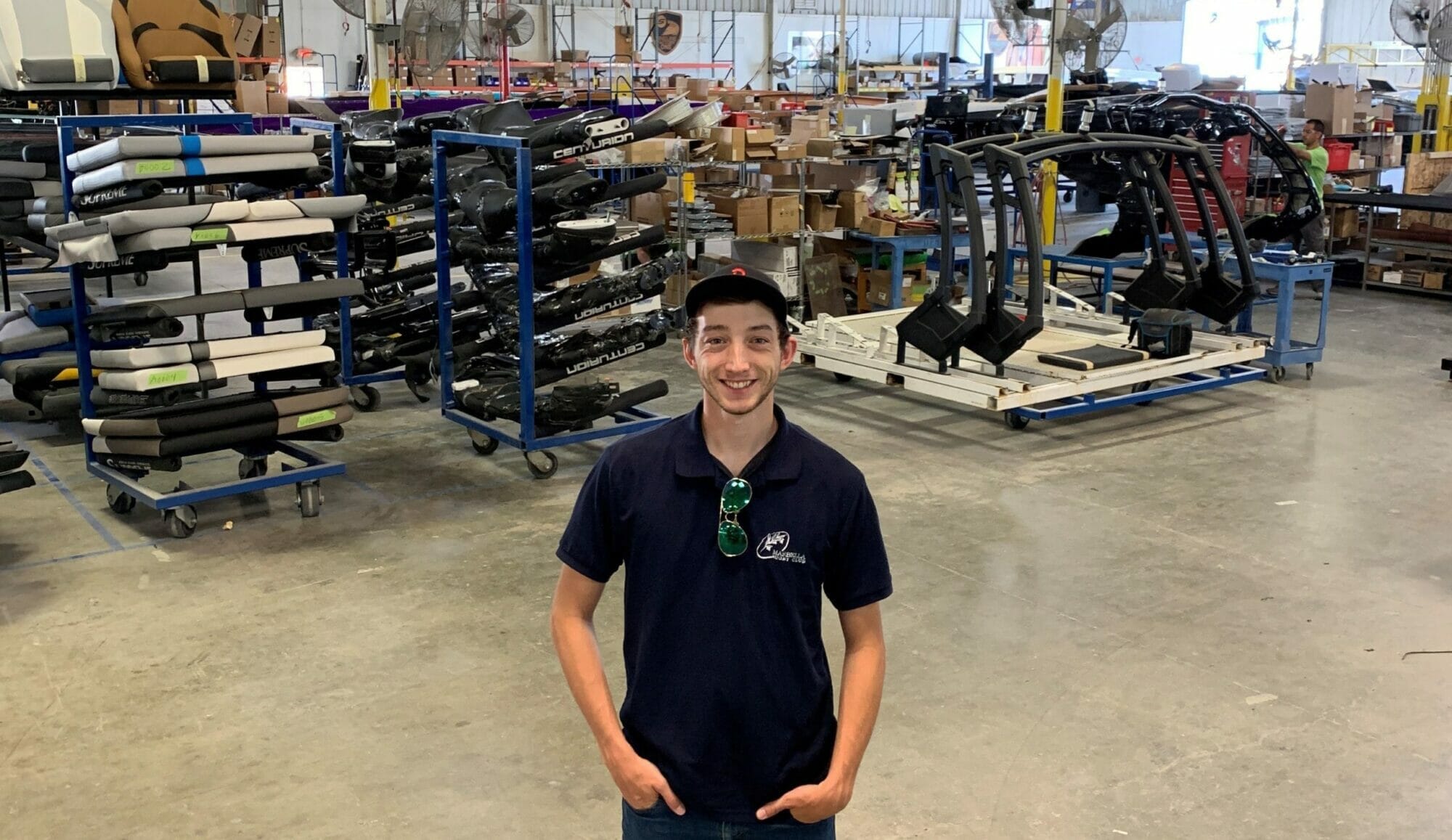 A young man in a warehouse full of Supreme Boats equipment.