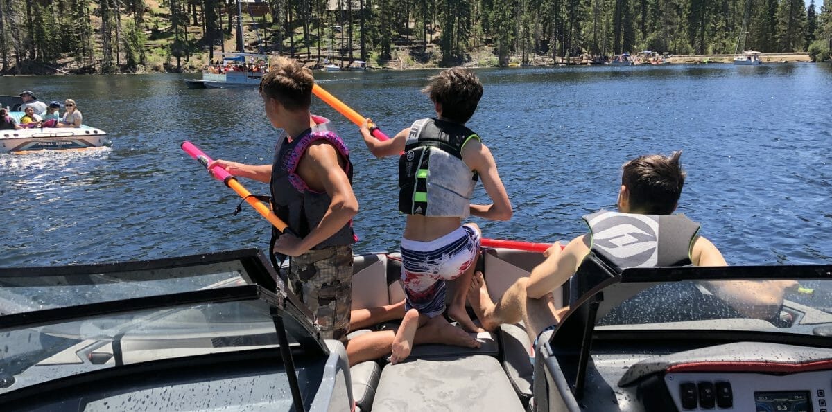 A group of people on a Supreme boat in a lake.