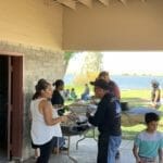 A group of people standing around a table with food at a Supreme Boats event.