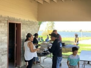 A group of people standing around a table with food at a Supreme Boats event.