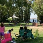 A group of people sitting in Supreme Boats near a lake.