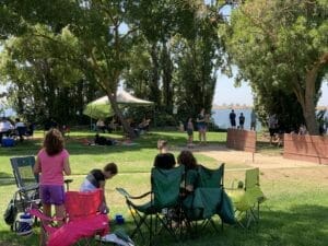 A group of people sitting in Supreme Boats near a lake.