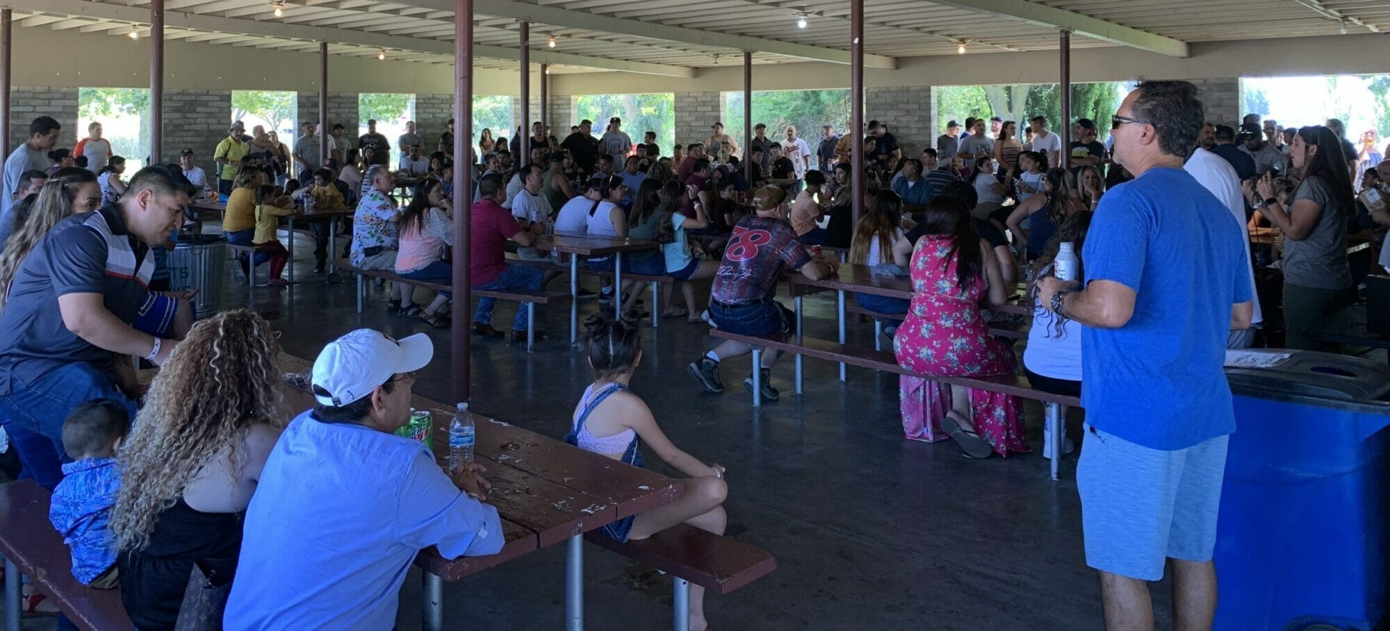 A crowd of people sitting at tables in an enclosed area at a Supreme Boats event.