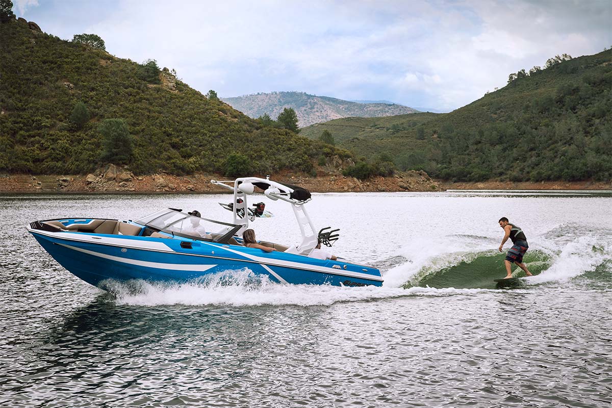 Supreme S238 action wake surfing with mountains in background