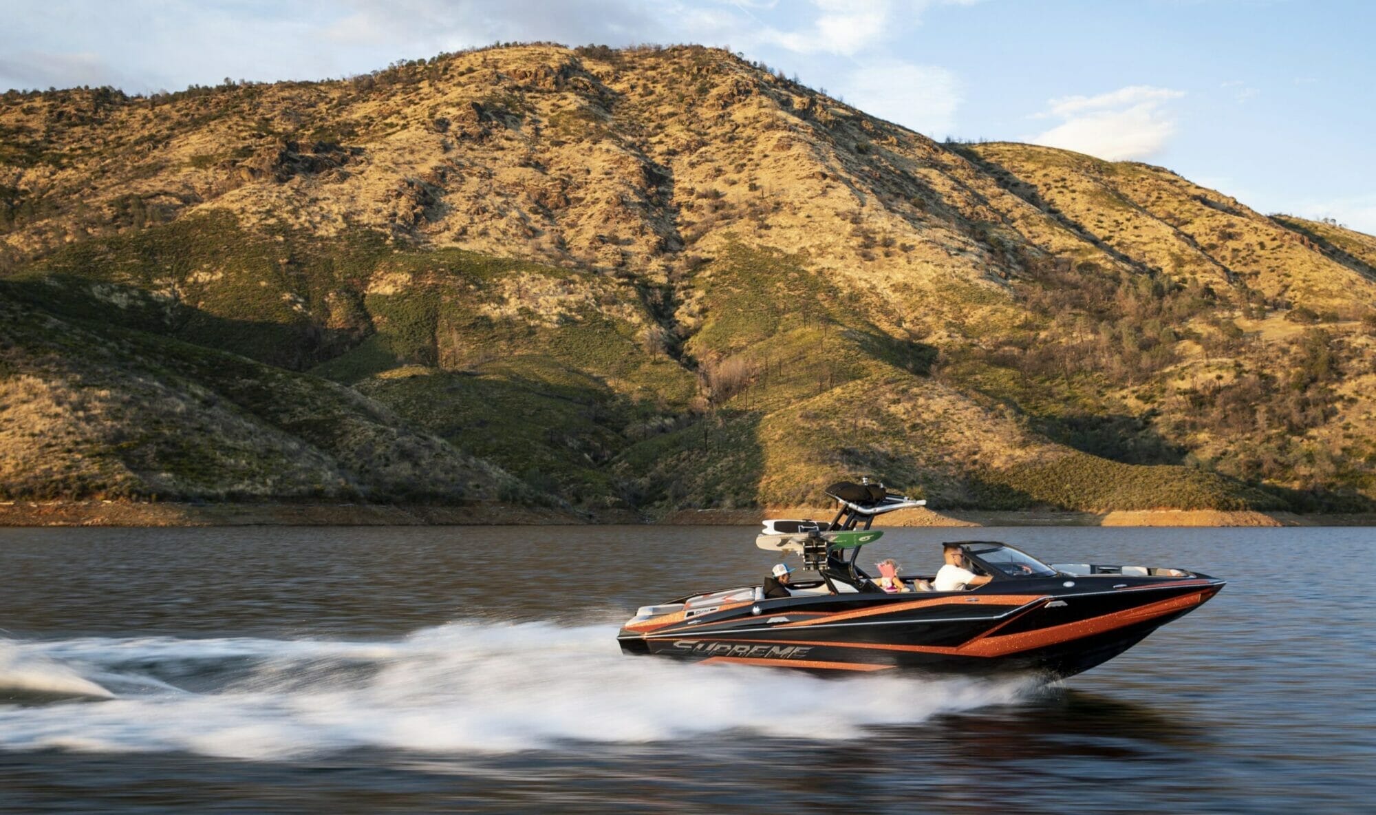 A man is riding a Supreme jet ski on a body of water.