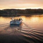 A Supreme boat on a lake at sunset.