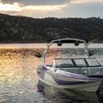 A Supreme boat sits on a lake at sunset.