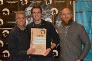 Three men posing with a Supreme Boats plaque in front of a banner.