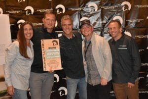 A group of people posing for a picture with a plaque at Supreme Boats.