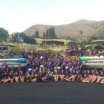 A group of people posing in front of a Supreme boat.