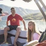 A group of people sitting in the back of a Supreme boat.