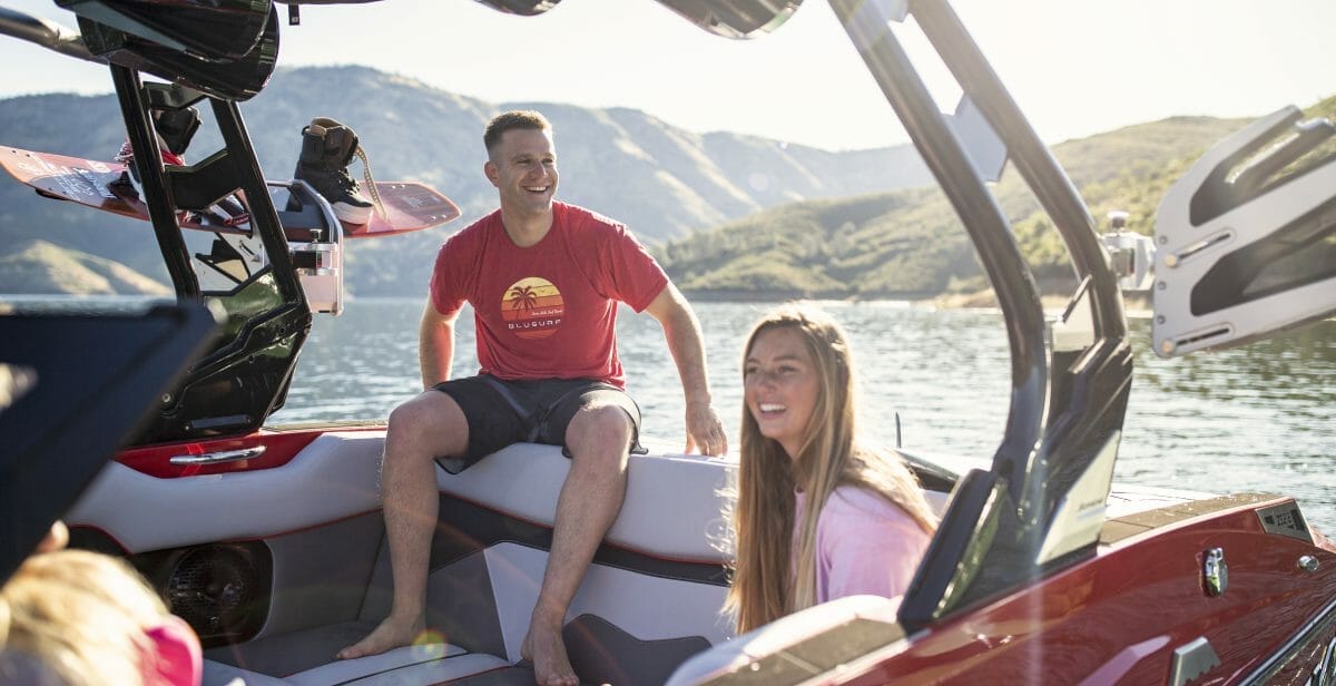 A group of people sitting in the back of a Supreme boat.