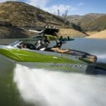 A green and white Supreme boat speeding through the water.