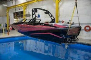 A Supreme wakeboard boat hanging in a garage.