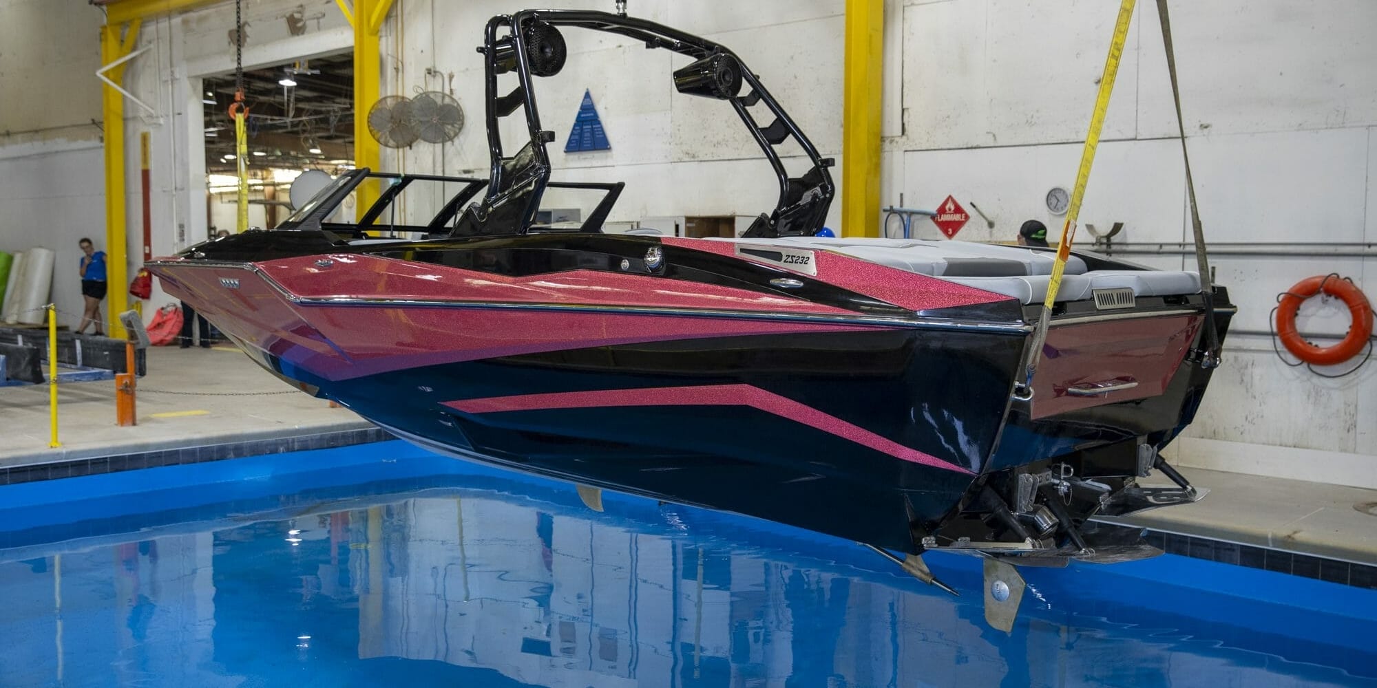 A Supreme wakeboard boat hanging in a garage.
