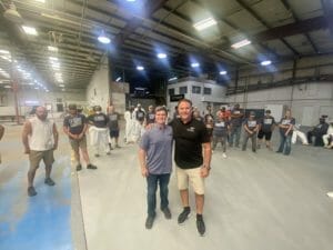 Two men standing next to each other in a Supreme warehouse.