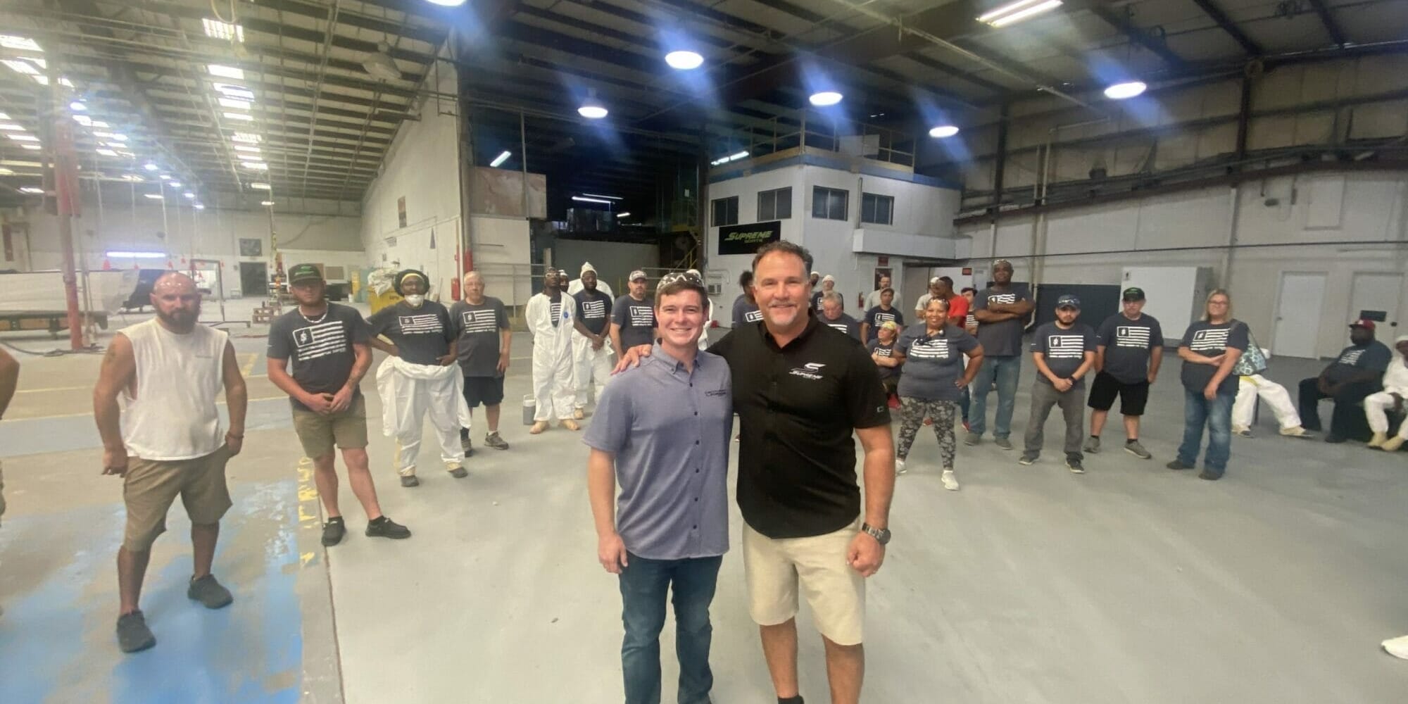 Two men standing next to each other in a Supreme warehouse.