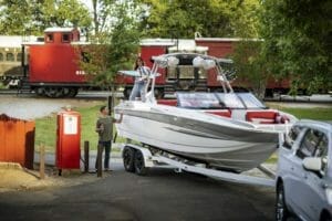 A Supreme boat is parked next to a train.