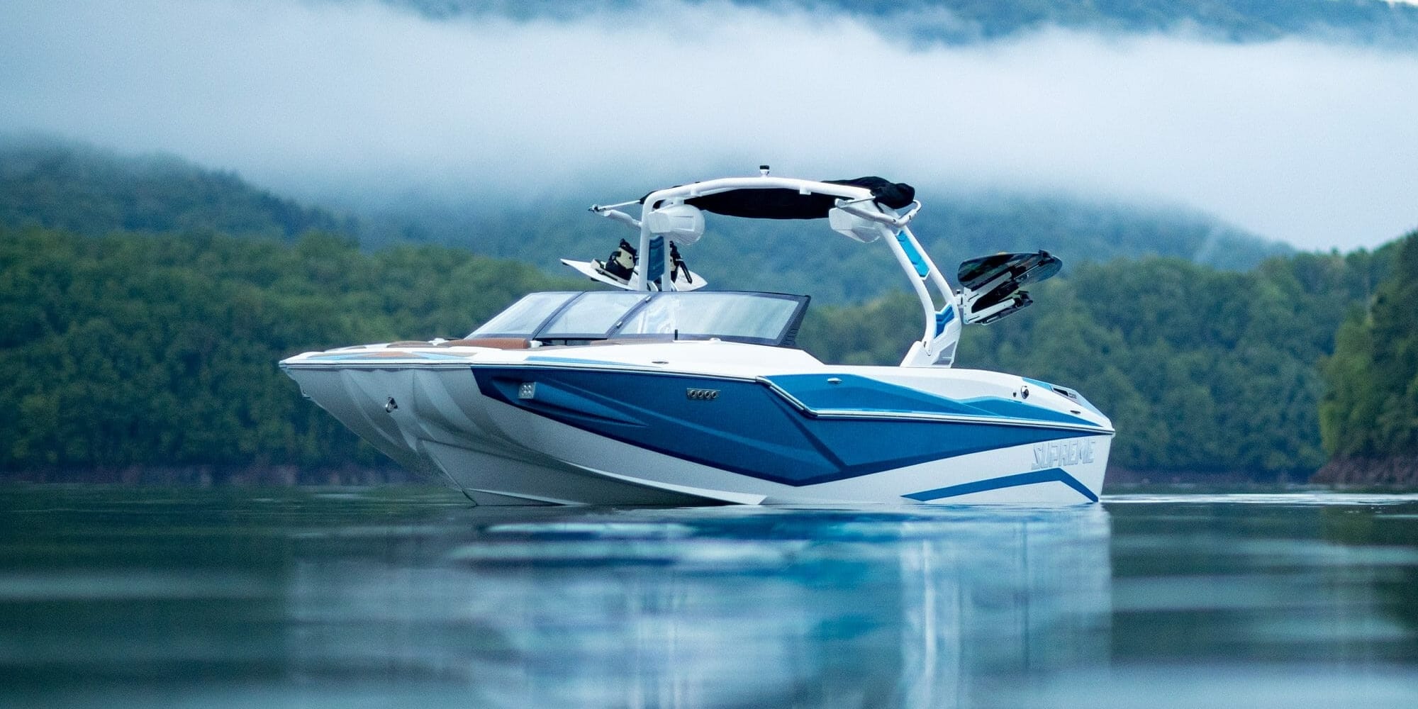 A SUPREME blue and white speed boat on a body of water.