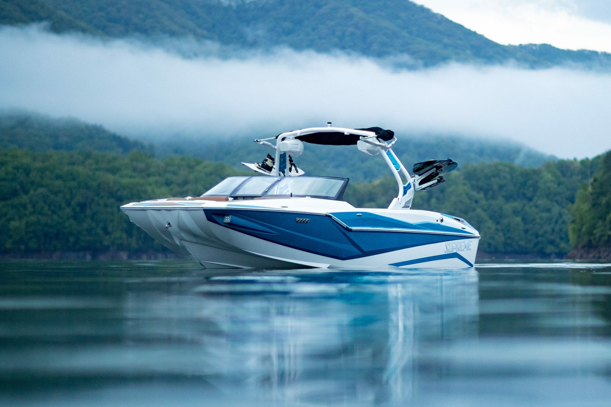 A SUPREME blue and white speed boat on a body of water.