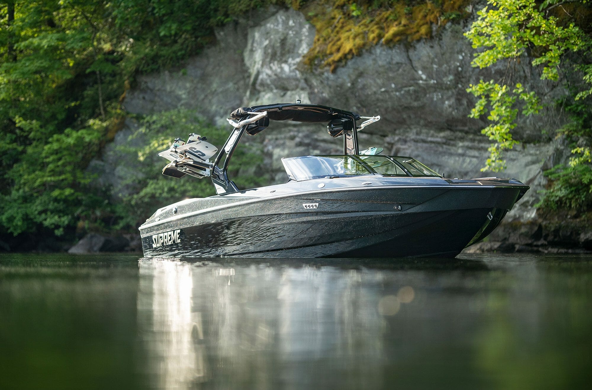 A Supreme boat is floating down a river.