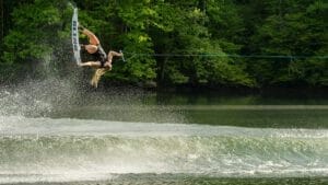 A woman is wakeboarding behind a Supreme boat.