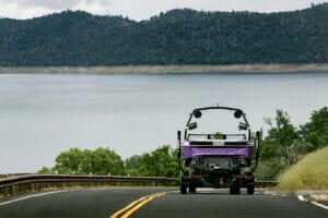 Purple S220 Supreme boat on a trailer moving toward lake