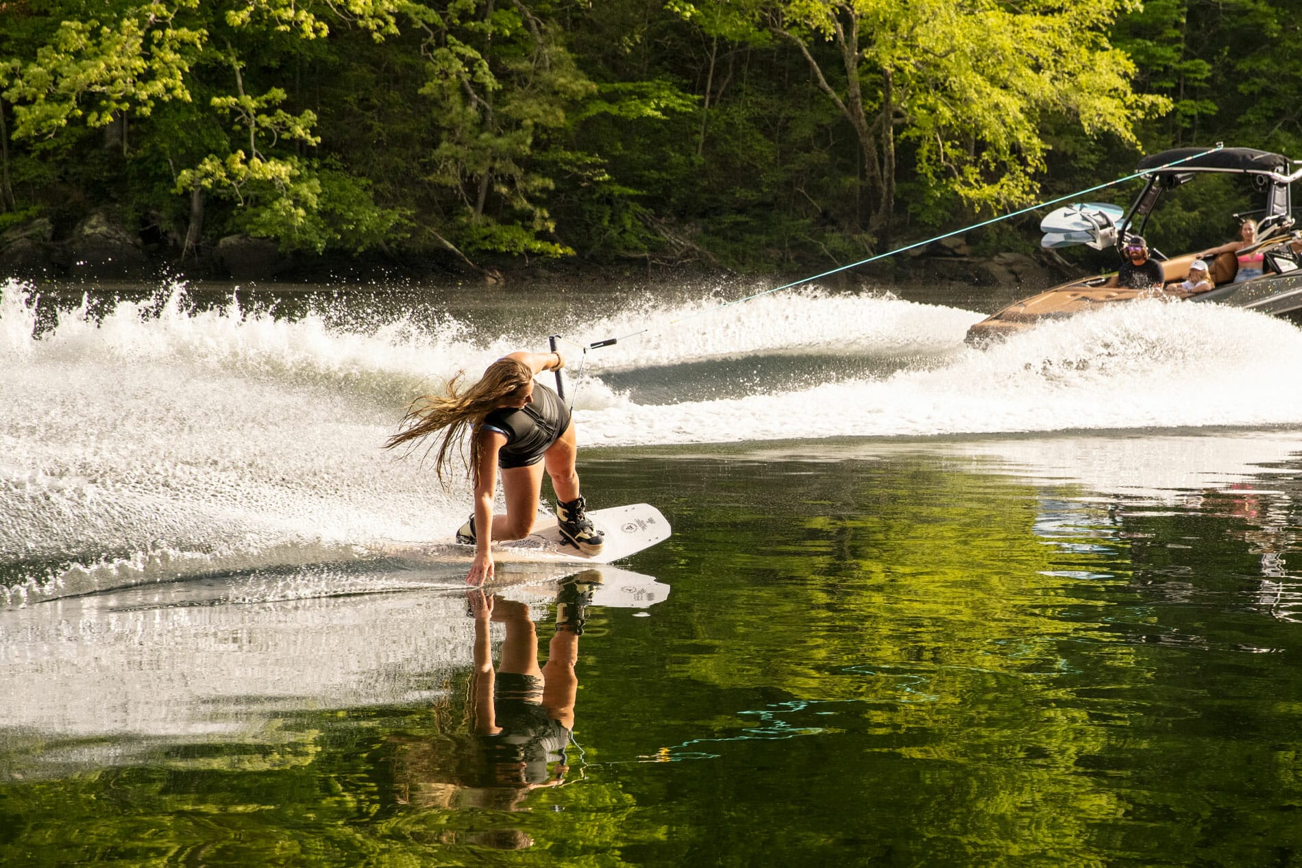 A woman water skiing on a lake with Supreme Boats.