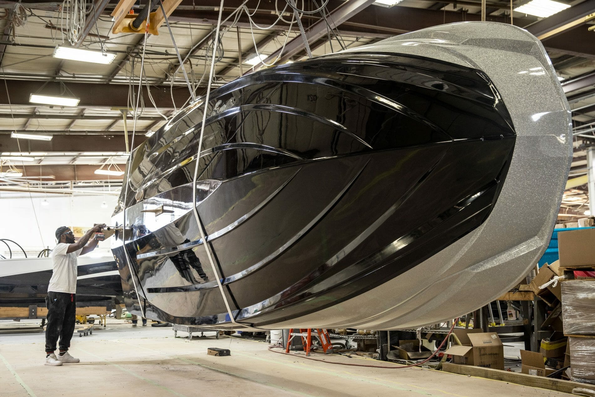 A man is working on a Supreme boat in a factory.