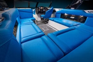 Luxurious boat interior with vibrant blue seating, a sleek control console, and modern design elements emphasizing comfort and style, all featured in the Supreme S240.