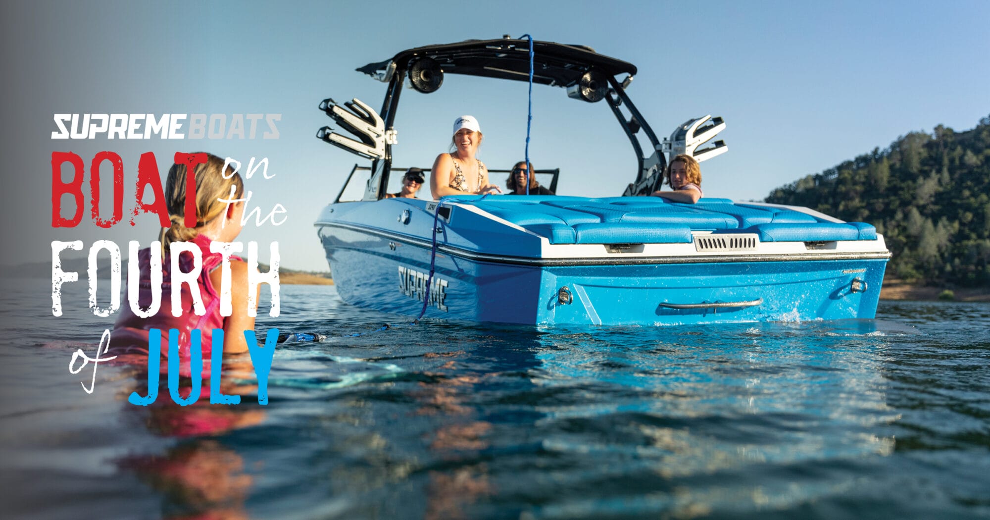 A group of people relax on a blue boat in a lake, with 